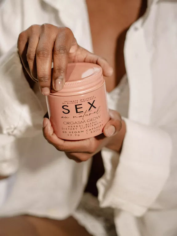 Orgasm Glow - Supplément alimentaire à base de plantes tenu en main.